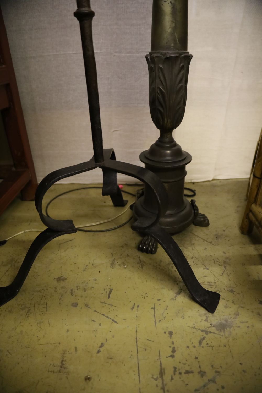 A wrought iron church style candlestand and a metal standard lamp and shade